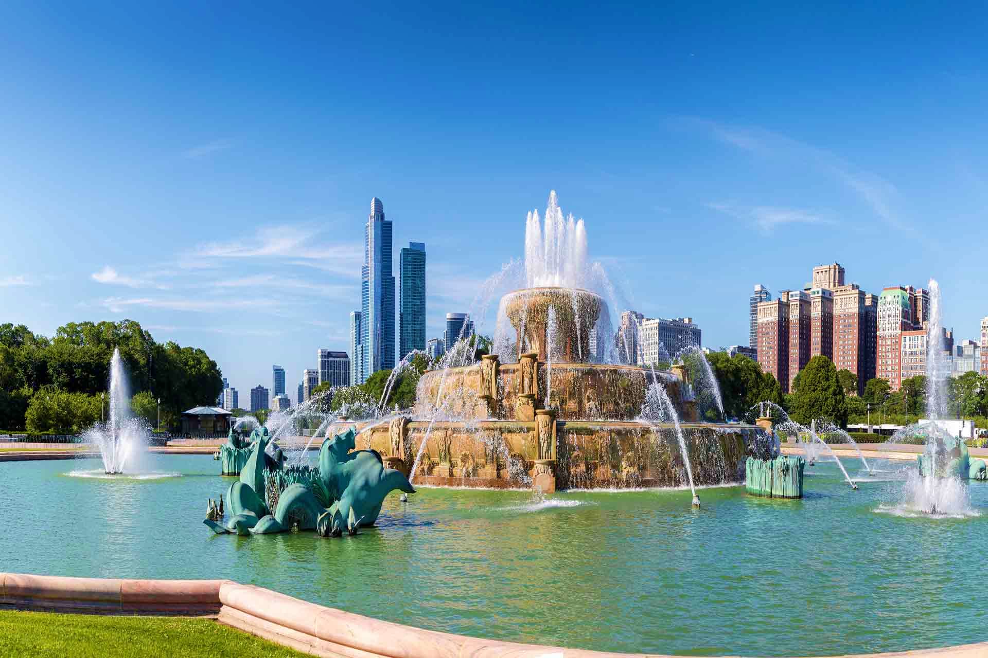 USA Visa Buckingham Fountain in Grant Park, Chicago with city skyline and turquoise water jets